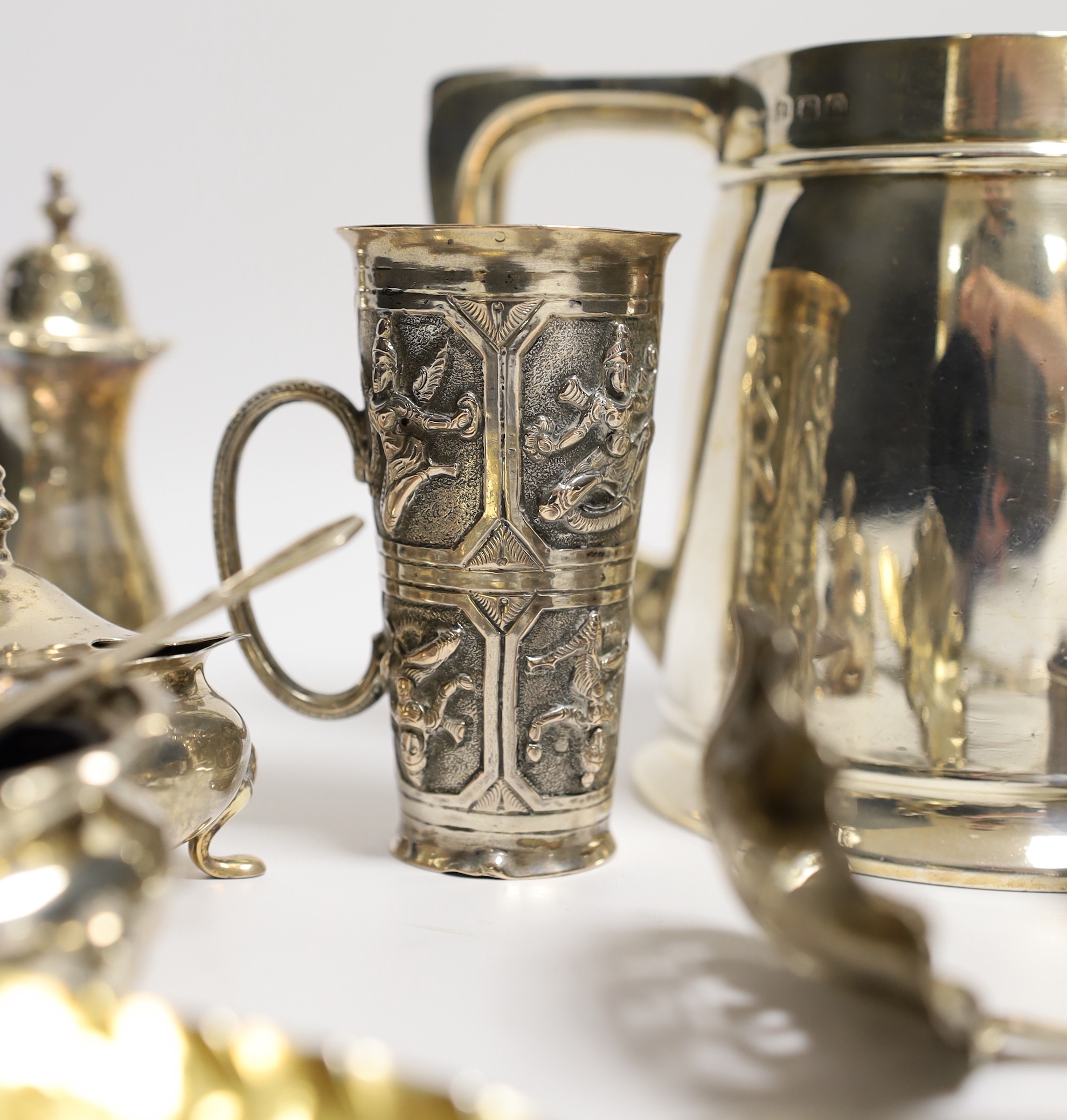 A George VI silver mug, Birmingham, 1937, 11.5cm with engraved inscription to Wing Commander E.E.M Angell, a pair of George III Old English pattern berry spoons, a George IV silver caddy spoons and other items including